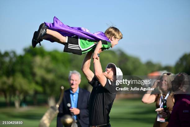 Peter Malnati of the United States hoists his son over the Valspar Championship Trophy after the final round of the Valspar Championship at...
