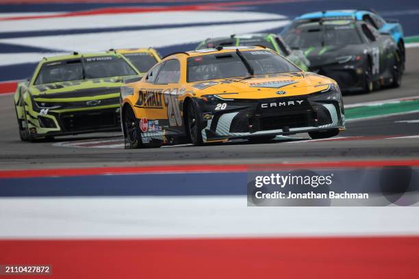 Christopher Bell, driver of the DEWALT Toyota, and William Byron, driver of the RaptorTough.com Chevrolet, race during the NASCAR Cup Series EchoPark...