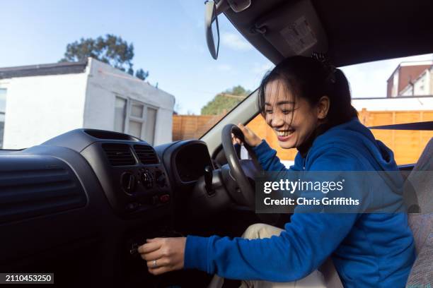 Young Adult Southeast Asian Filipino Woman Prepares For A Shopping Trip In Her Car At A Residential Home Driveway In Bristol England United Kingdom Europe, Foto de stock