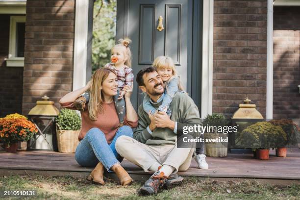 giovane famiglia che si diverte in una giornata di sole - proprietario di casa foto e immagini stock