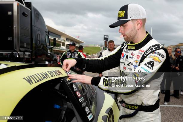 William Byron, driver of the RaptorTough.com Chevrolet, places the winner sticker on his car after winning the NASCAR Cup Series EchoPark Automotive...