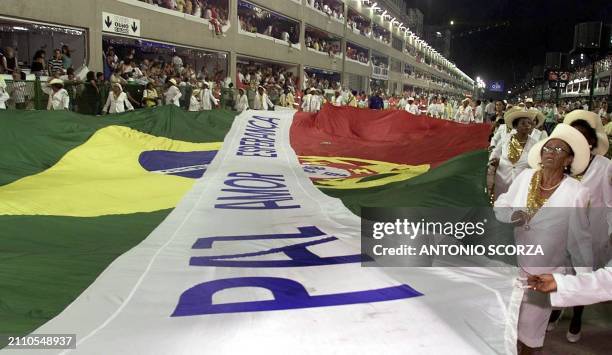 Members of the samba school, United to the Tijuca, lifted their giant flag 06 March, 2000 in Rio de Janeiro, Brazil. Integrantes de la escuela de...