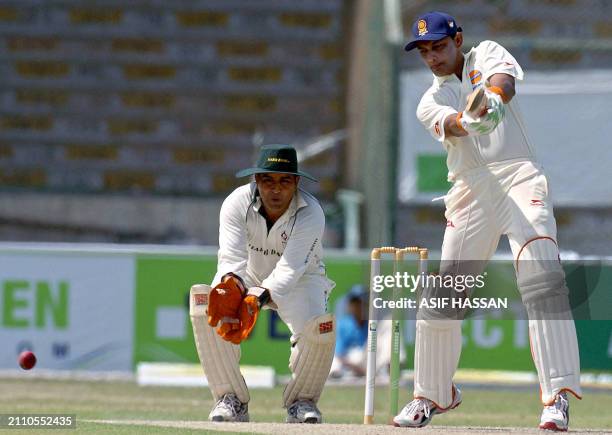 Former Indian cricket captain Mohammad Azharuddin plays a shot as Pakistani wicketkeeper Azam Khan looks on during the first One Day match of a four...