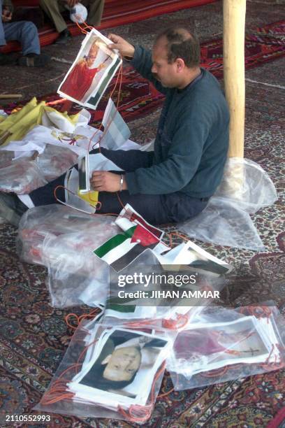 Jordanian volunteer strings together pictures of Pope John Paul II and Jordanian King Abdullah II at Wadi Kharrar, 18 March 2000, two days before the...