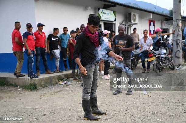 Man lights firecrackers to celebrate the inauguration of a health centre and delivery of an ambulance, both jointly funded by local communities and...