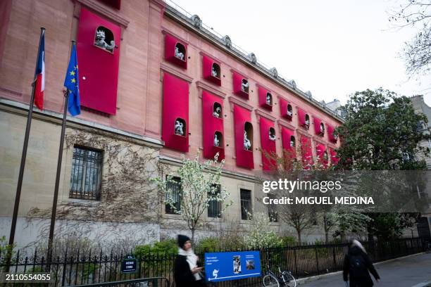 Woman stands in front of the facade of the Asian arts Guimet Museum, dressed by Chinese artist Jiang Qiong Er, in center Paris on March 27, 2024. In...