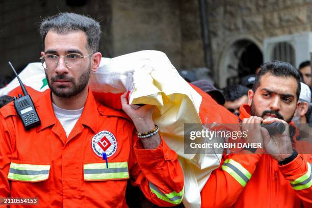 Members of the Lebanese NGO Emergency and Relief Corps carry the body of one of the victims killed in overnight Israeli bombardment, during the...