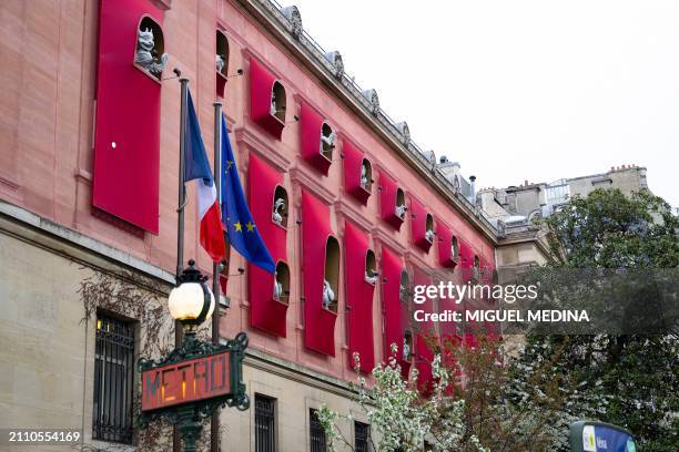 This photograph taken in center Paris on March 27 shows a subway entrance sign next to the facade of the Asian arts Guimet Museum, dressed by Chinese...