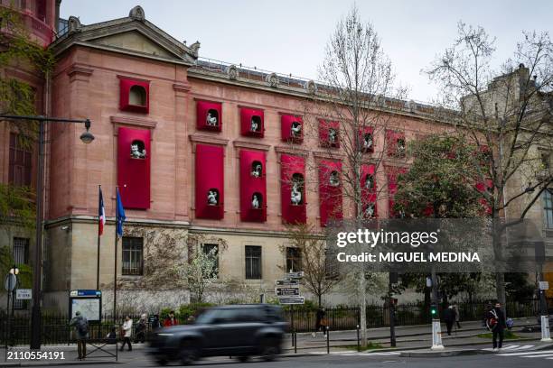 Car drives past the facade of the Asian arts Guimet Museum, dressed by Chinese artist Jiang Qiong Er, in center Paris on March 27, 2024. In 2024, the...