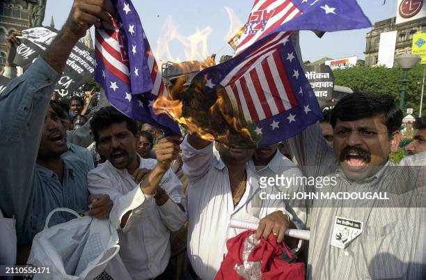 Activists of the Communist Party of India - Marxist burn US flags during a demonstration in downtown Bombay to greet US President Bill Clinton 24...
