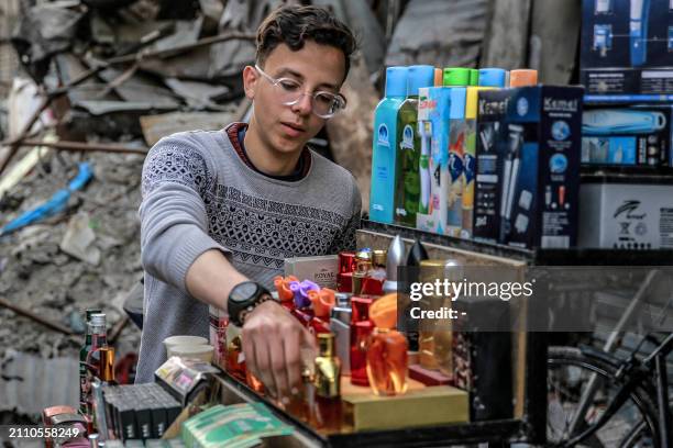 Street vendor sells perfumes, lotions, toothbrushes, and haircare accessories at a stall along an open-air market in Gaza City on March 27, 2024 amid...