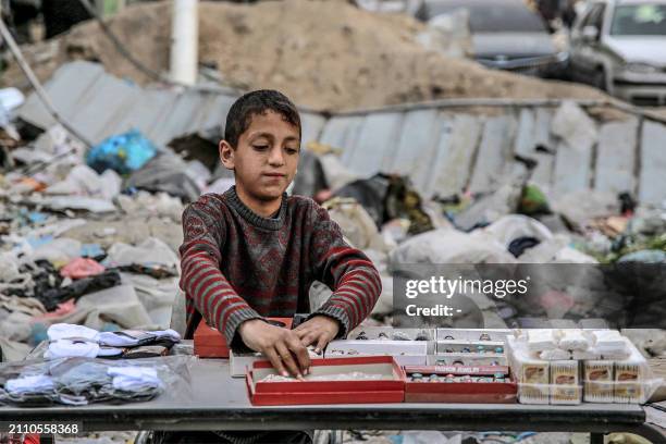 Vendor arranges his merchandise of accessories at his stall in an open-air market amidst destruction in Gaza City on March 27, 2024 amid the ongoing...