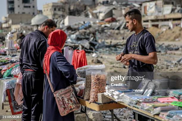People shop for nuts from a vendor in an open-air market amidst destruction in Gaza City on March 27, 2024 amid the ongoing conflict in the Gaza...