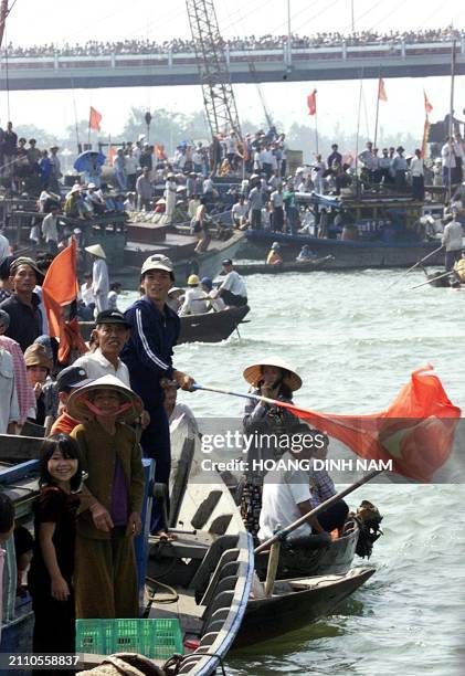 Man waves a flag to encourage his favorite team during a boat race organised, 28 March 2000 on the Han river in the central city of Da Nang, as part...