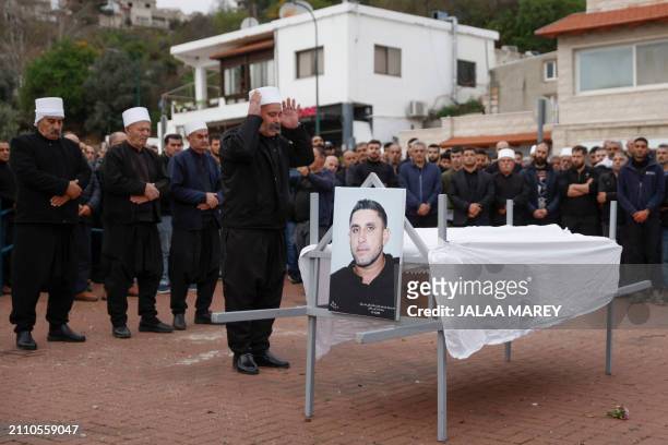 Mourners pray over the casket of Zaher Bishara, a Druze man from the village of Ein Qiniyya in the Israel-annexed Golan heights, killed in an...