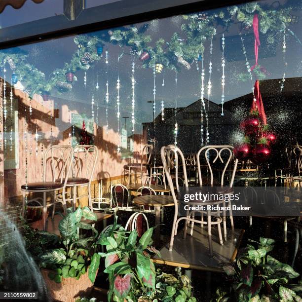 Chairs are on tables in the window of a restaurant closed for the Christmas holidays, in the City of London, the capital's financial district, on...