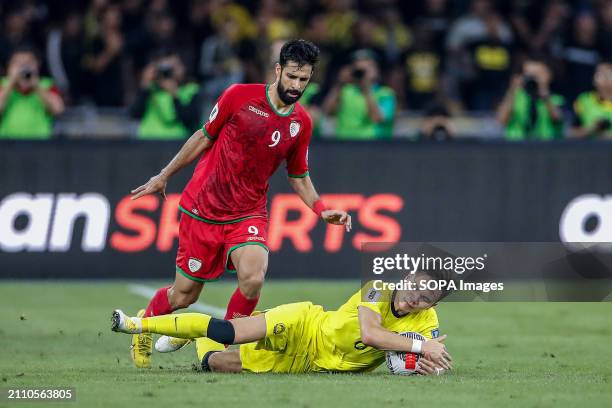 Omer Al Malki of Oman and Stuart Wilkin of Malaysia in action during the 2026 World Cup/2027 Asian Cup Qualifiers Group D match between Malaysia and...