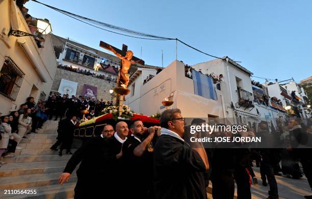 Penitents from the 'Santa Cruz' brotherhood carry steps down an effigy of Jesus Christ on the cross at 'Cristo de la Fe', popularly known as the...