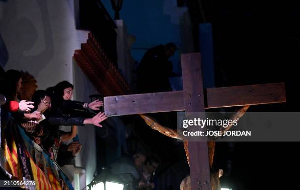 Penitents from the 'Santa Cruz' brotherhood carry an effigy of Jesus Christ on the cross at 'Cristo de la Fe', popularly known as the gypsy Christ,...