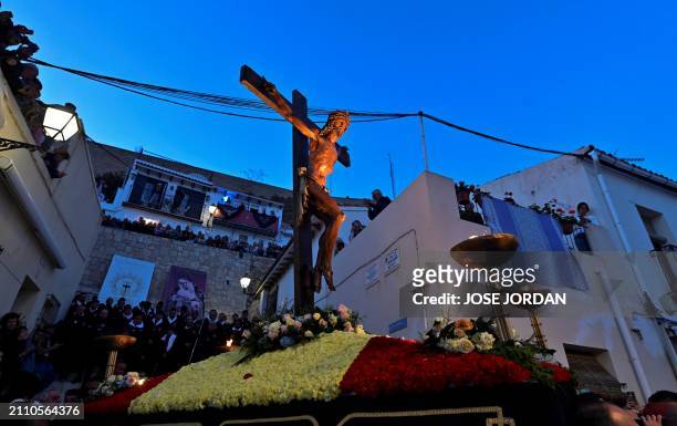 Penitents from the 'Santa Cruz' brotherhood carry steps down an effigy of Jesus Christ on the cross at 'Cristo de la Fe', popularly known as the...