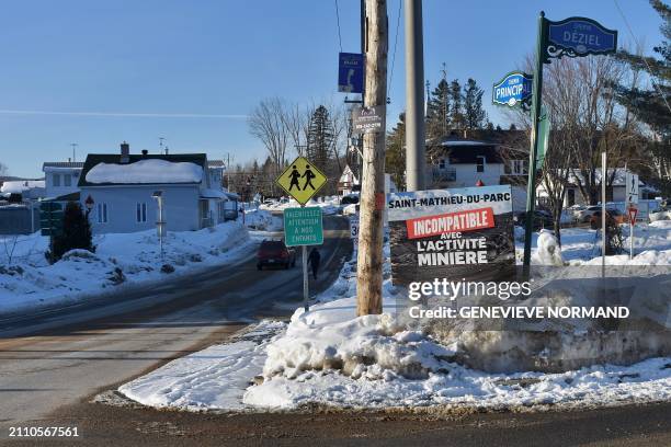 Poster reading "Saint-Mathieu-du-Parc, incompatible with mining activity" is posted on the main street of the village on February 20, 2024 in...