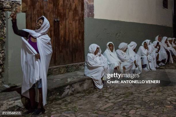 Catholic women dressed in white sheets take part in the Terno das Almas procession in Igatu on the Chapada Diamantina National Park, Bahia State,...