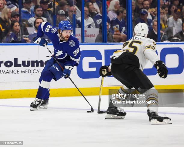 Brandon Hagel of the Tampa Bay Lightning against Brandon Carlo of the Boston Bruins during the third period at Amalie Arena on March 27, 2024 in...