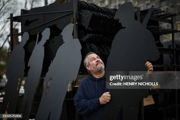 British artist Dan Barton poses next to stacks of finished WW2 soldier silhouettes, during the preparation of "Standing with Giants" project, at...