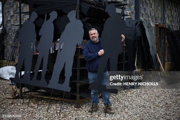 British artist Dan Barton poses next to stacks of finished WW2 soldier silhouettes, during the preparation of "Standing with Giants" project, at...