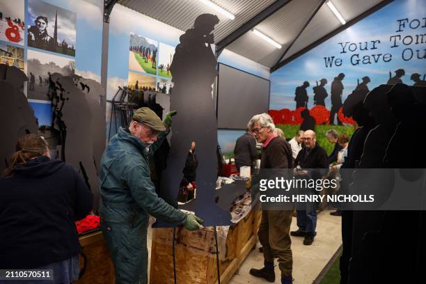 Volunteers attach metal stands to WW2 soldier silhouettes during the preparation of "Standing with Giants" project, at Cutmill Farm, in Stanton...