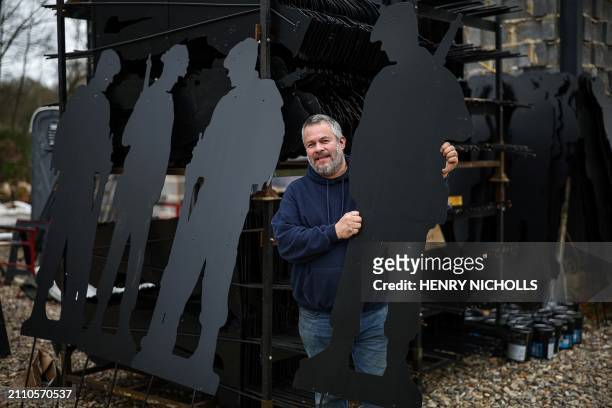 British artist Dan Barton poses next to stacks of finished WW2 soldier silhouettes, during the preparation of "Standing with Giants" project, at...
