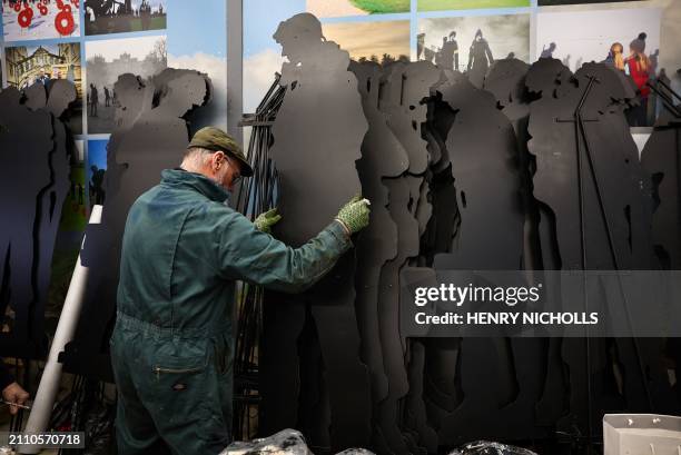 Volunteer stacks completed WW2 soldier silhouettes during the preparation of "Standing with Giants" project, at Cutmill Farm, in Stanton Harcourt,...