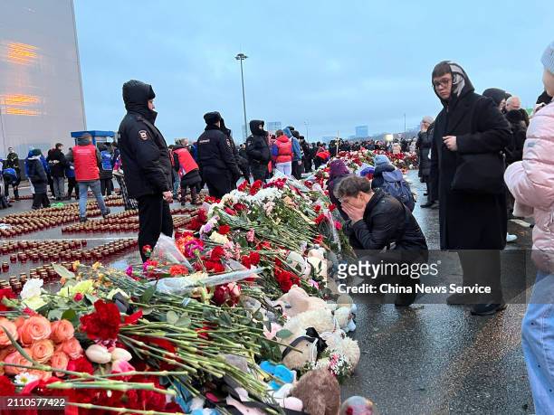 People lay flowers at the makeshift memorials for the victims of the terrorist attack at the "Crocus City Hall" concert venue on March 24, 2024 in...