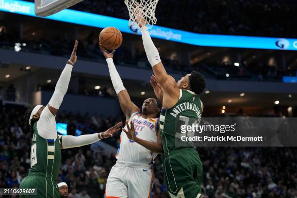 Jalen Williams of the Oklahoma City Thunder shoots the ball against Jae Crowder and Giannis Antetokounmpo of the Milwaukee Bucks during the first...