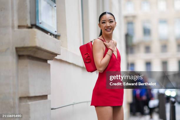 Yuwei Zhangzou wears a red micro dress over red micro shorts, a red Valentino bag, outside Valentino , during the Womenswear Fall/Winter 2024/2025 as...