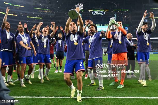 Sergiño Dest of the United States lifts the Concacaf Nations League Trophy as he celebrates with teammates after defeating Mexico in the Concacaf...