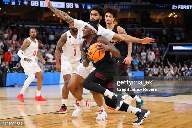 Tyrece Radford of the Texas A&M Aggies drives to the basket against Damian Dunn of the Houston Cougars during overtime in the second round of the...