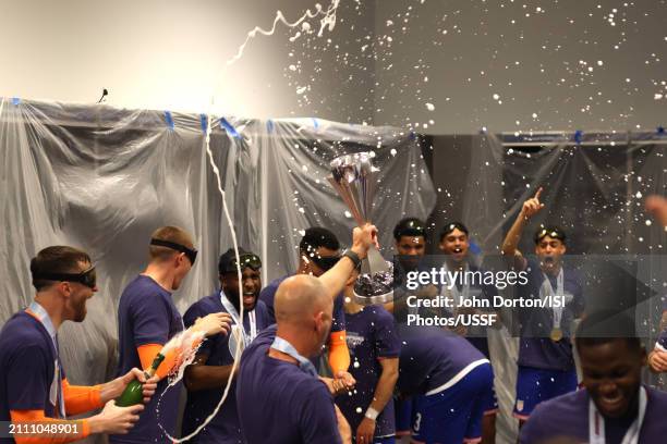 United States head coach Gregg Berhalter holds the Concacaf Nations League Trophy as the team celebrate in the locker room after defeating Mexico in...