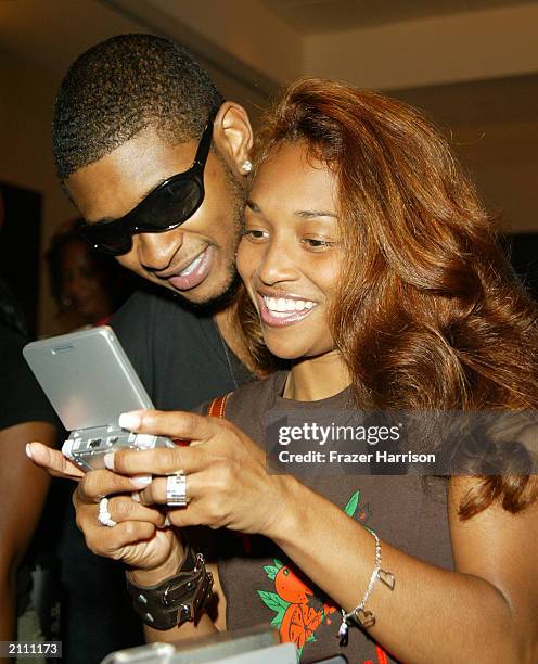 Singers Usher and girlfriend Chilli from TLC play the Nintendo Game Boy at the Smirnoff Ice Triple Black Lounge during the 3rd Annual BET Awards,...