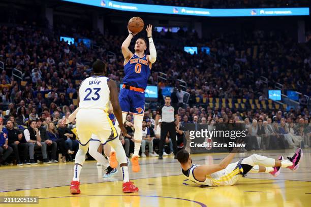 Donte DiVincenzo of the New York Knicks shoots over Draymond Green and Stephen Curry of the Golden State Warriors at Chase Center on March 18, 2024...