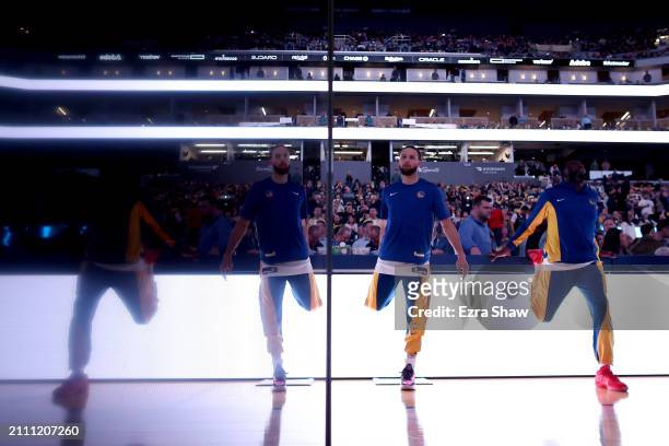 Stephen Curry and Draymond Green of the Golden State Warriors warm up before their game against the New York Knicks at Chase Center on March 18, 2024...