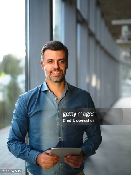 happy businessman day dreaming while using touchpad in a hallway. - entrepreneur stockfoto's en -beelden