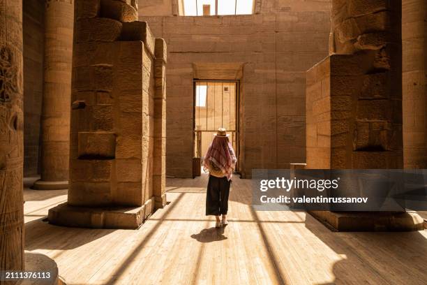 mujer caminando en el templo de philae, también conocido como templo de isis en asuán, egipto, isla de agilkia - aswan fotografías e imágenes de stock