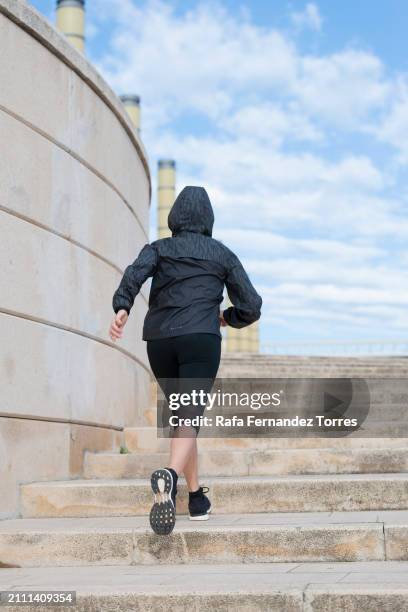 a female mature runner running up a set of stairs in barcelona. - looking from rear of vehicle point of view stock pictures, royalty-free photos & images