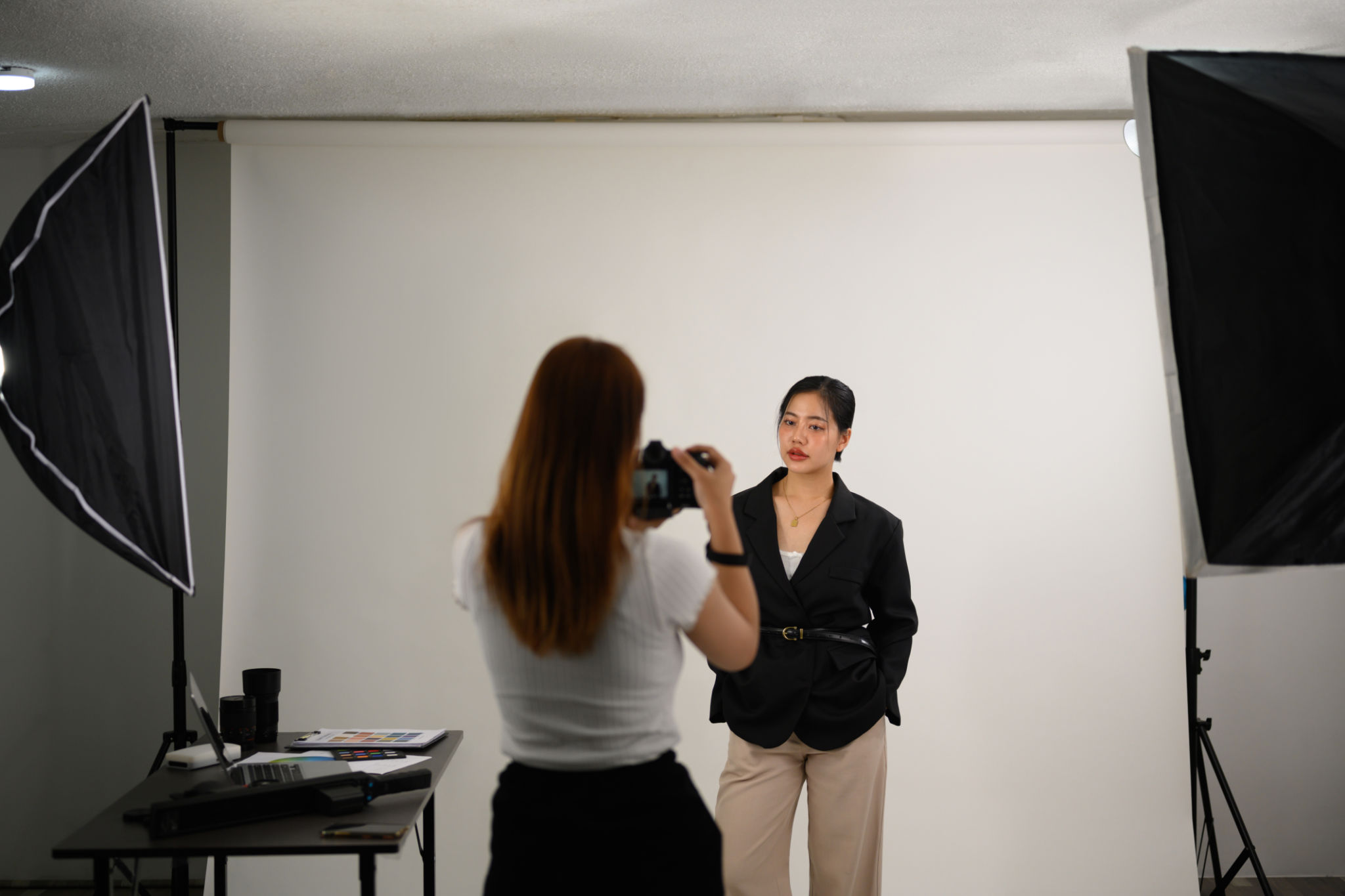 Fashion photographer taking picture of young female model in lighting studio Fashion photographer taking picture of young female model in lighting studio