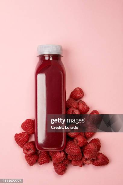 a plastic bottle of healthy red juice on a colourful background - fruit juice stock pictures, royalty-free photos & images
