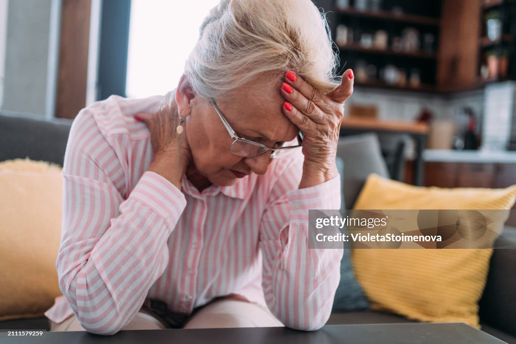 Senior woman suffering with a migraine.