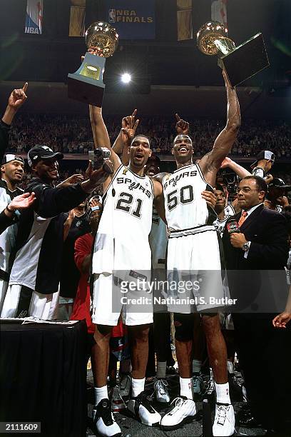 Tim Duncan and David Robinson of the San Antonio Spurs hoist the NBA Finals MVP Award and the Championship trophy after winning Game six of the 2003...