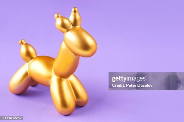 balloon animal on purple background - animal representation stock pictures, royalty-free photos & images