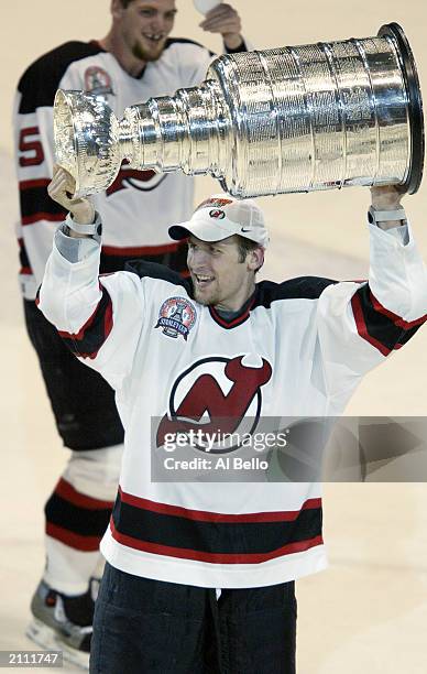 Mike Rupp of the New Jersey Devils hoists the Stanley Cup after defeating the Mighty Ducks of Anaheim in game seven of the 2003 Stanley Cup Finals at...